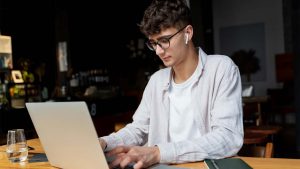 Homem estudando em computador para desenvolver as habilidades essenciais do mercado tech
