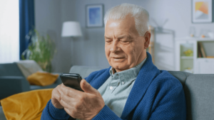 Homem de idade utilizando um celular para fazer a prova de vida