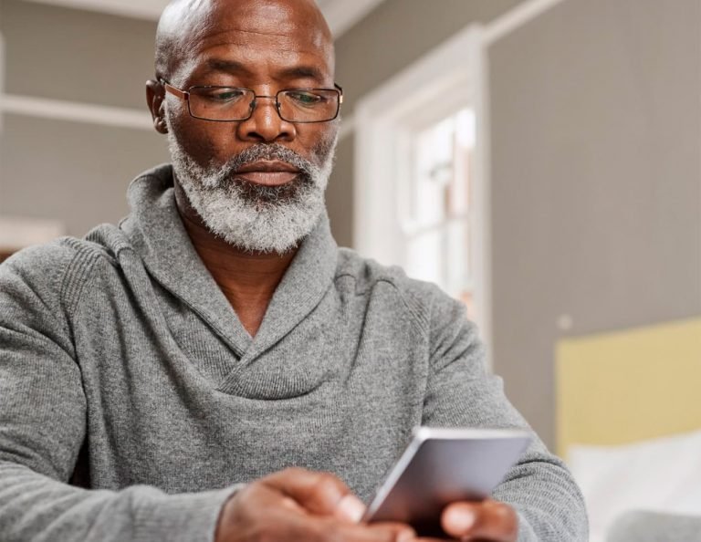 Homem de idade utilizando o LivID em um smartphone para realizar a prova de vida