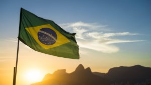 Gateware - Foto da bandeira do brasil à frente do por do sol no horizonte