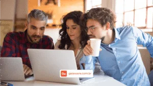 Profissionais de diferentes áreas analisam informações em um notebook durante reunião de alinhamento entre negócio e tecnologia para projetos de transformação digital e ERP.